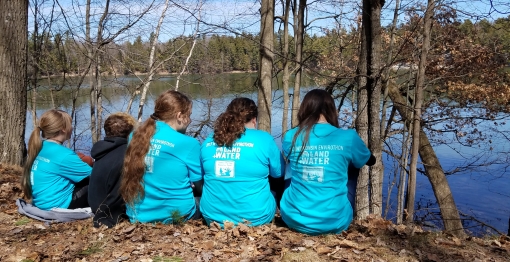 Environmental Education participants sitting by a river bank